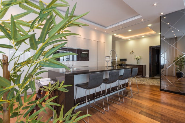 Interior of a modern kitchen with wood floors and a black island in Tarrant County